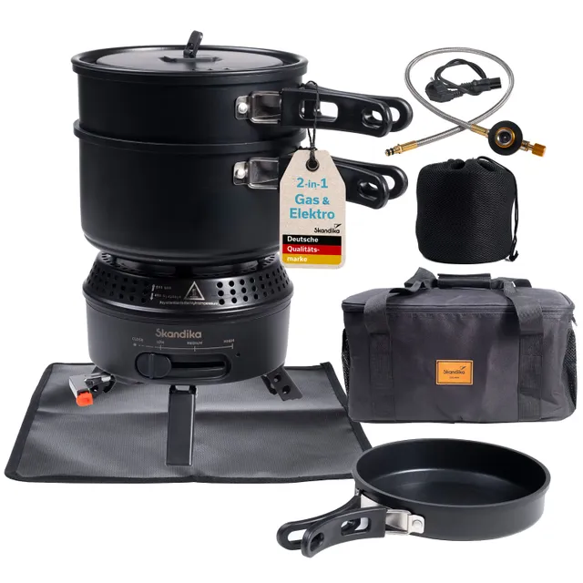 Campingkocher in Schwarz mit zwei Töpfen, einer Pfanne, einem Gasschlauch und einer Tasche. Zubehör auf einer grauen Matte.