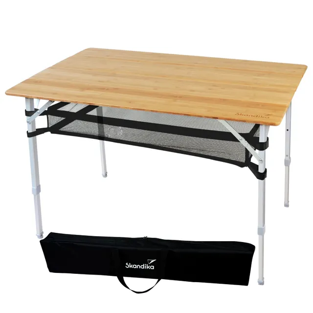 Klappbarer Tisch mit einer Holzplatte und Aluminiumbeinen. Unter der Tischplatte befindet sich ein schwarzes Netz. Eine Tragetasche ist im Bild sichtbar.
