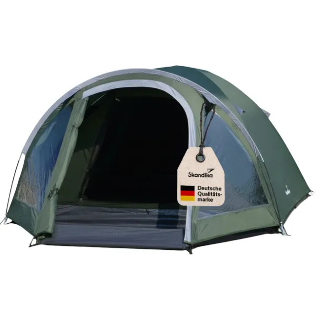 Grünes Zelt mit einem Eingangsbereich, an dem ein Etikett mit „Skandika“ und „Deutsche Qualitätsmarke“ hängt.