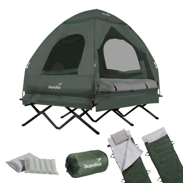 Zelt in Dunkelgrün mit Innenausstattung, zwei Schlafmatratzen, einem Kissen und einem gepackten Schlafsack.
