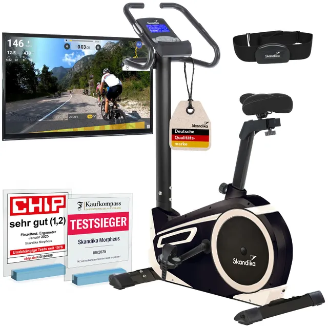 Ergometer mit Monitor, Herzfrequenzgurt und Auszeichnungen für gute Qualität. Bildschirm zeigt Fahrradtour im Freien.