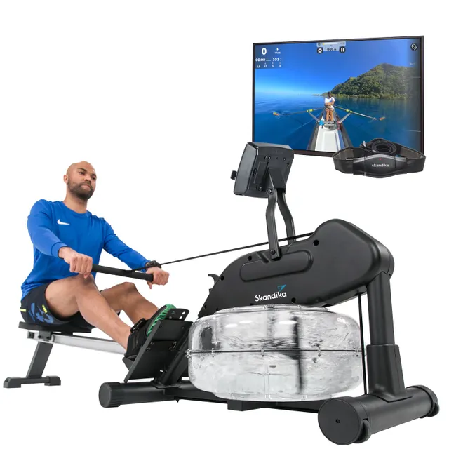 Rudergerät mit Wasserwiderstand, digitale Anzeige und Bildschirm im Hintergrund. Eine Person sitzt aktiv am Gerät.