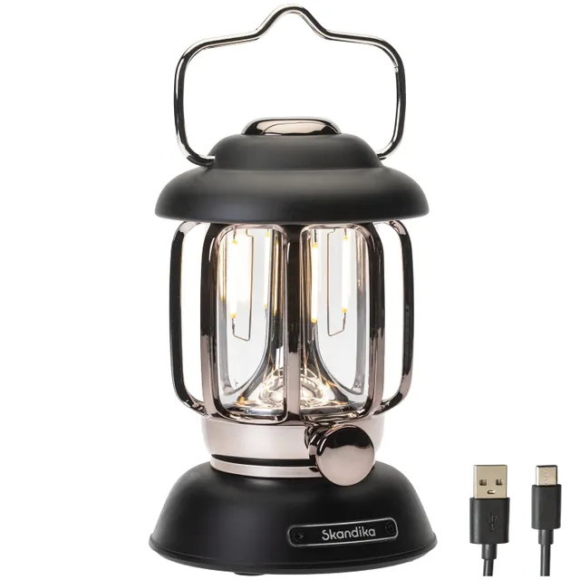 Tischlampe in Vintage-Optik mit einem schwarzen oberen Gehäuse und klaren Glaselementen. Kabel mit USB-Anschluss sichtbar.